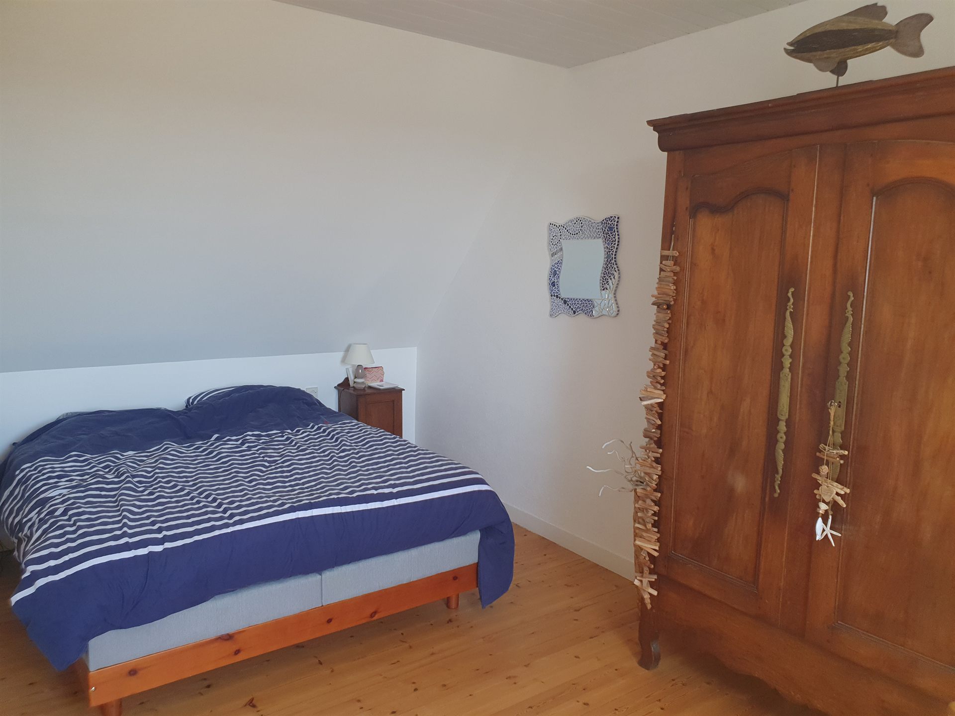 Chambre avec lit double et ambiance marine, parquet en bois