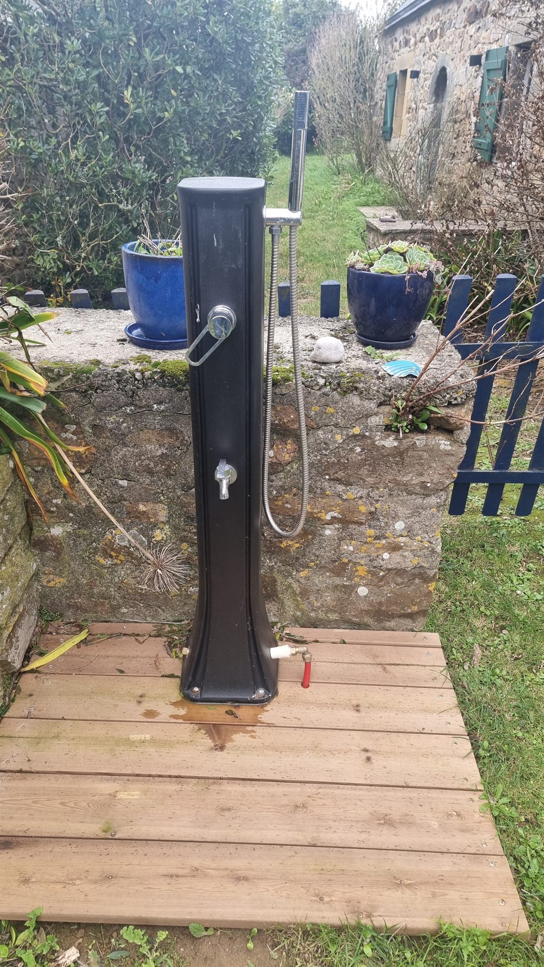 Douche solaire extérieure dans le jardin de la maison