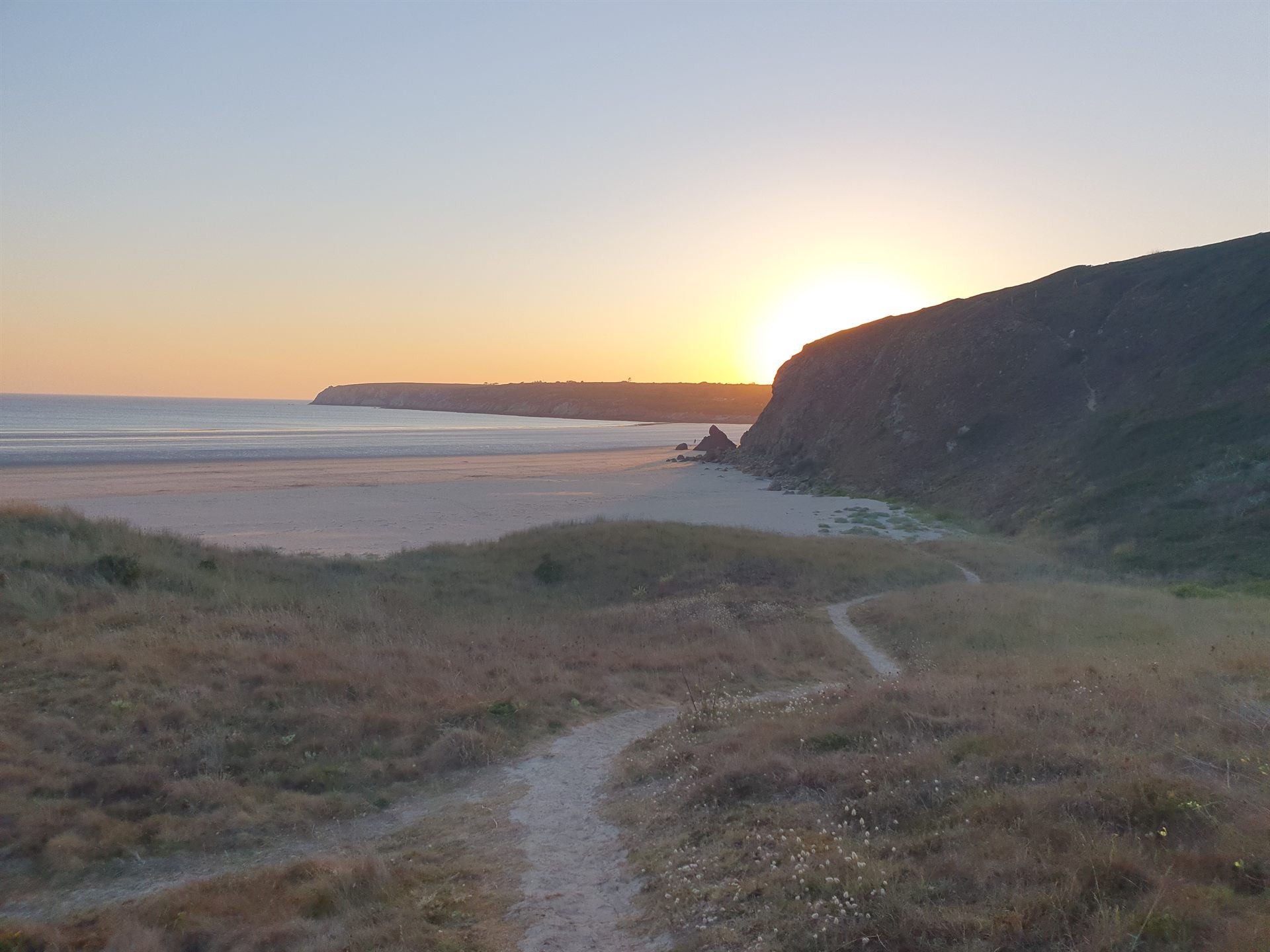 Plage de Kersiguenou au coucher du soleil, sable doré et vagues de l'Atlantique